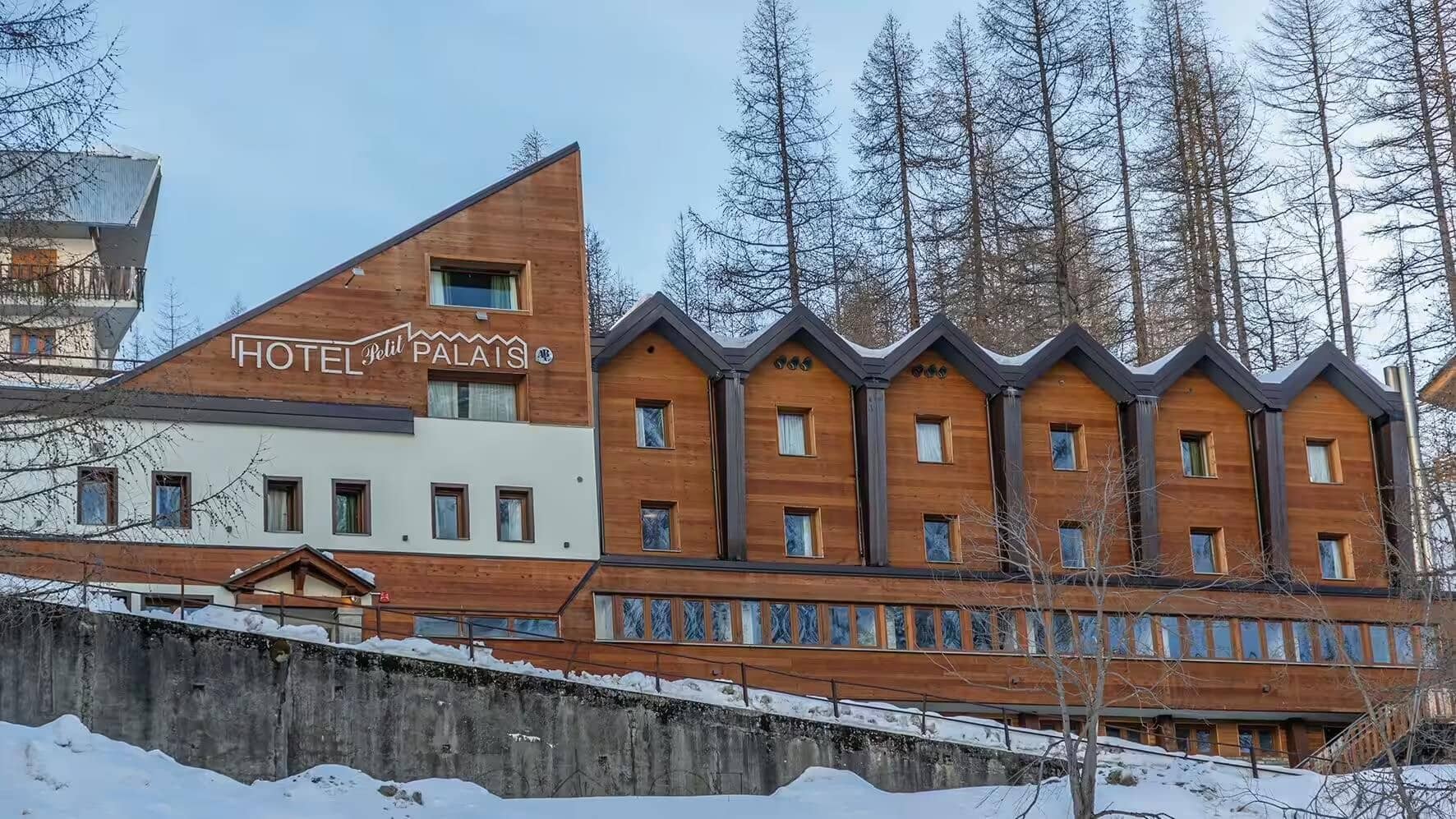 Hotel exterior with ski-in access and wooded mountain surroundings
