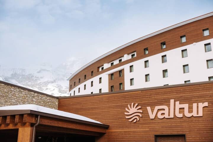 Resort exterior with Valtur signage and snow-capped mountain backdrop