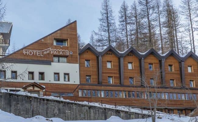 Ski-in/ski-out hotel exterior with timber cladding and forest backdrop
