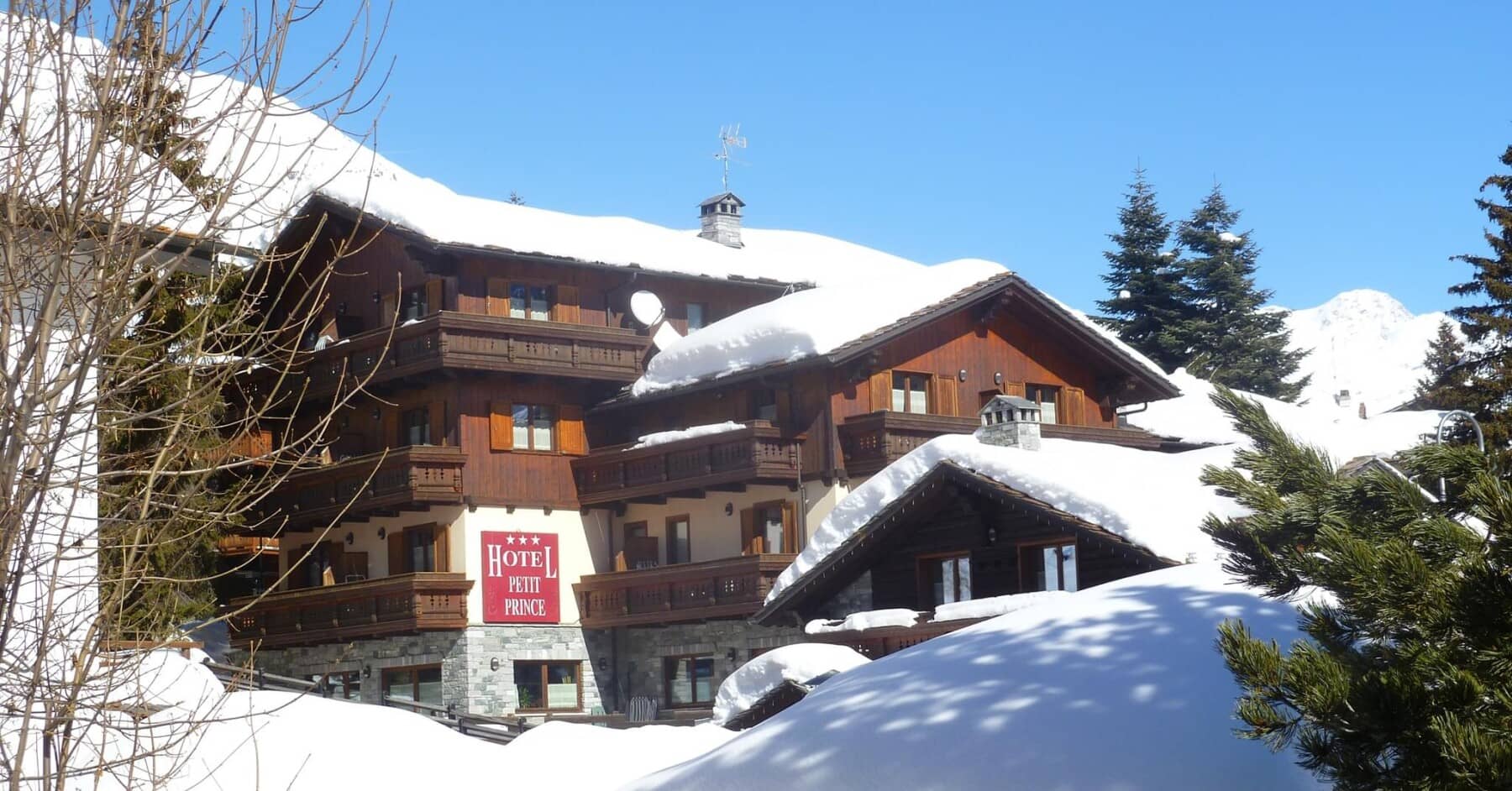 Ski-in/ski-out hotel exterior with multiple private balconies and mountain views