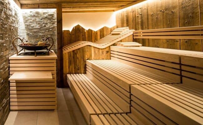 Finnish sauna with tiered wood seating and ergonomic reclining bench