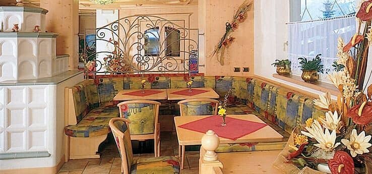 Dining area with traditional kachelofen tile stove and banquette seating