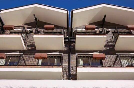 Private balconies featuring integrated planter boxes and stone facade