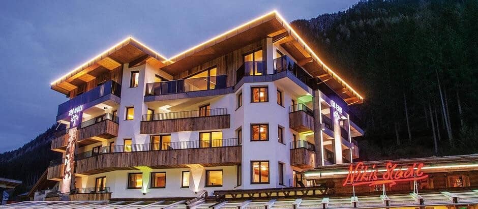 Chalet exterior with private balconies and mountain forest backdrop
