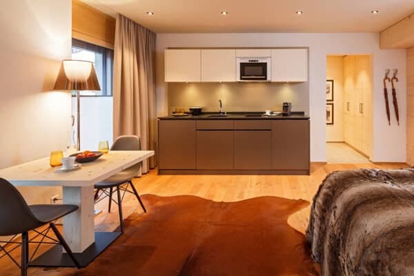 Studio kitchenette with induction cooktop, microwave, and dining seating for two