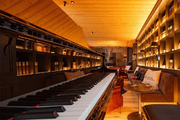Lounge area featuring grand piano and library wall seating