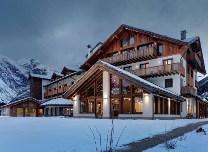 Alpine lodge with private balconies and floor-to-ceiling windows; mountain views