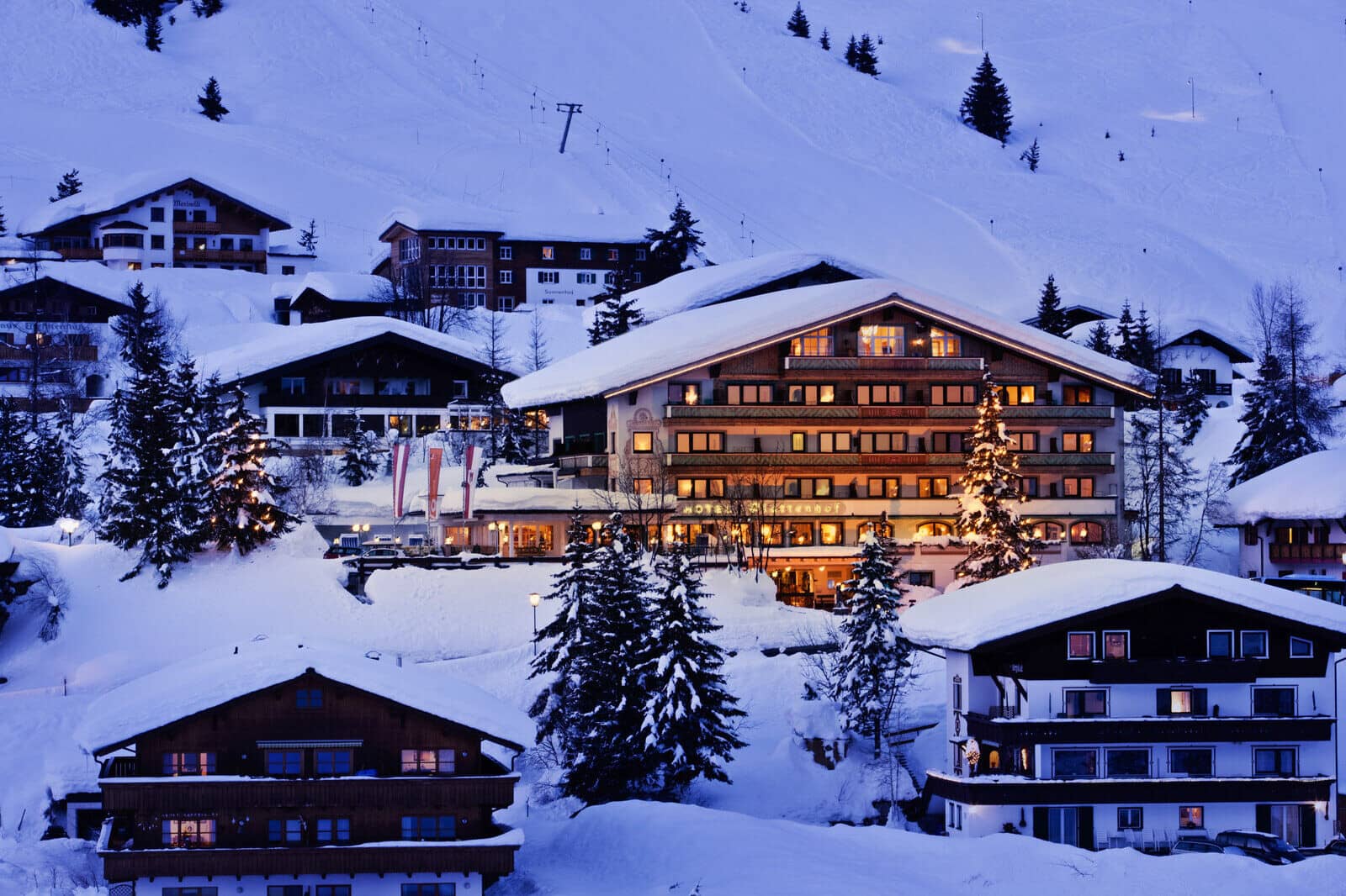 Alpine chalet village at dusk with direct access to ski slopes