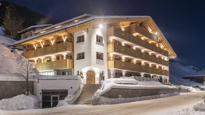 Chalet exterior at night with private balconies and underground parking access