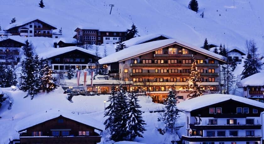 Alpine lodge exterior with direct ski lift and slope access