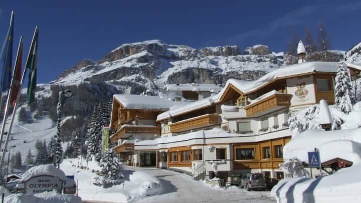 Chalet-style hotel exterior with private balconies and mountain backdrop