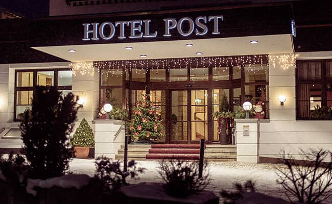 Hotel entrance featuring covered walkway, stairs, and holiday decor