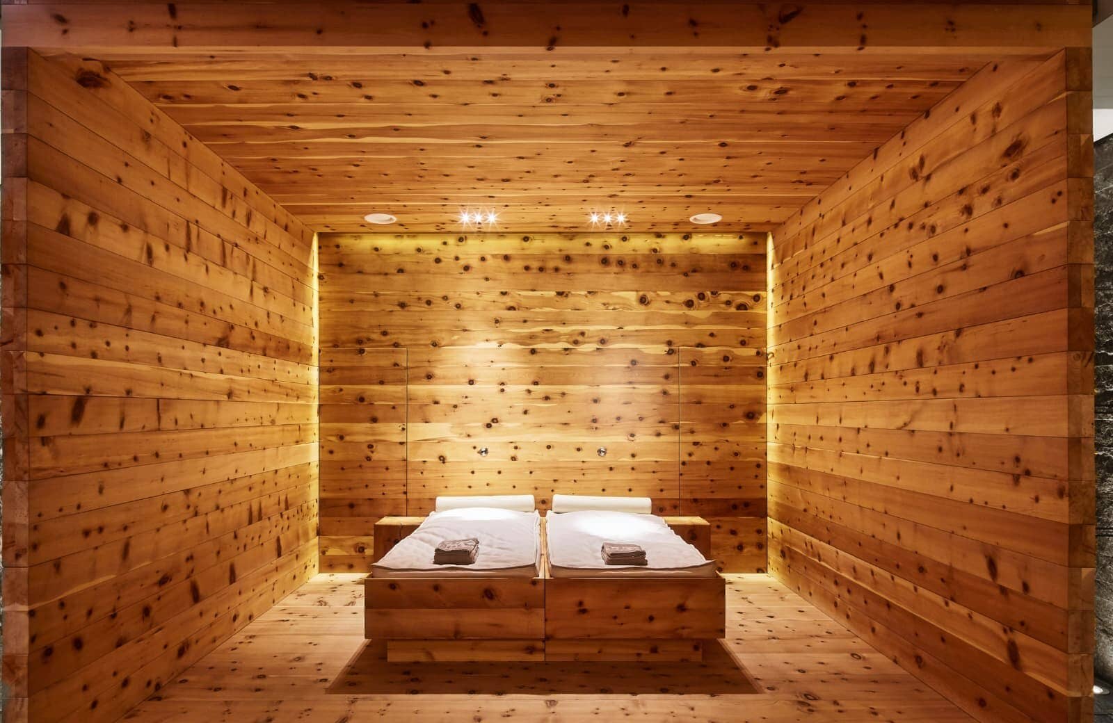 Cedar-lined wellness room with two heated relaxation beds and ambient lighting