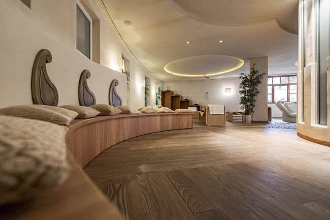 Spa relaxation room featuring curved wood bench and lounge seating