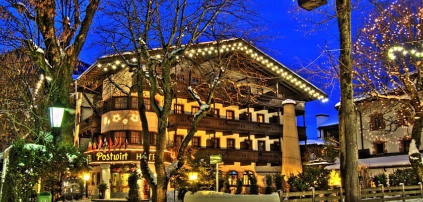 Chalet exterior at dusk with private balconies and festive lighting