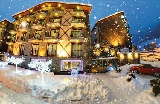 Ski-in/ski-out hotel exterior with private balconies and street-level parking