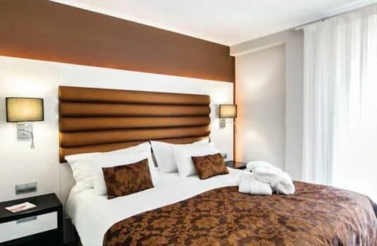 Bedroom with king bed, reading lamps, and blackout curtains