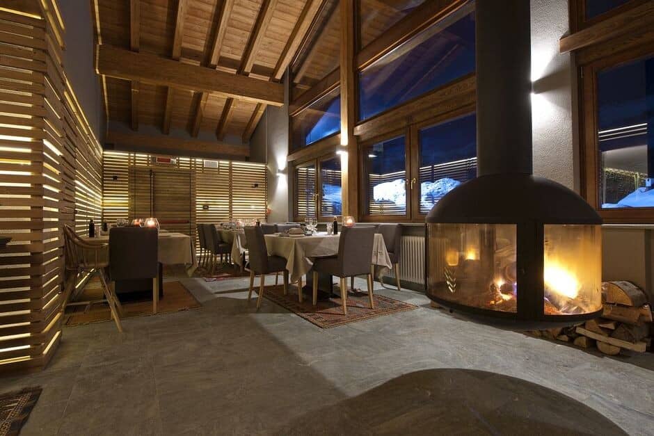 Dining area with suspended fireplace and mountain views