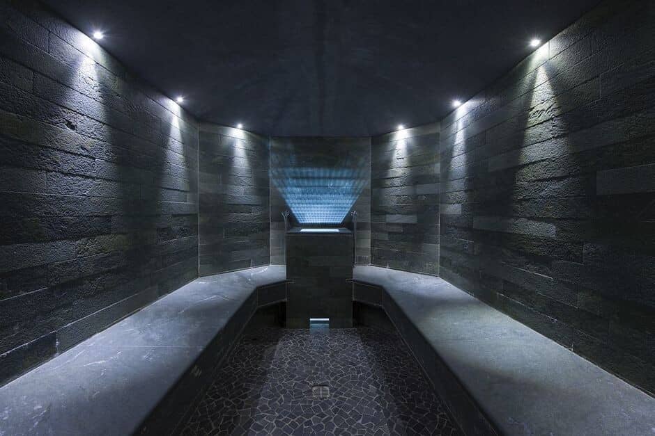 Private steam room with natural stone walls and wraparound benches