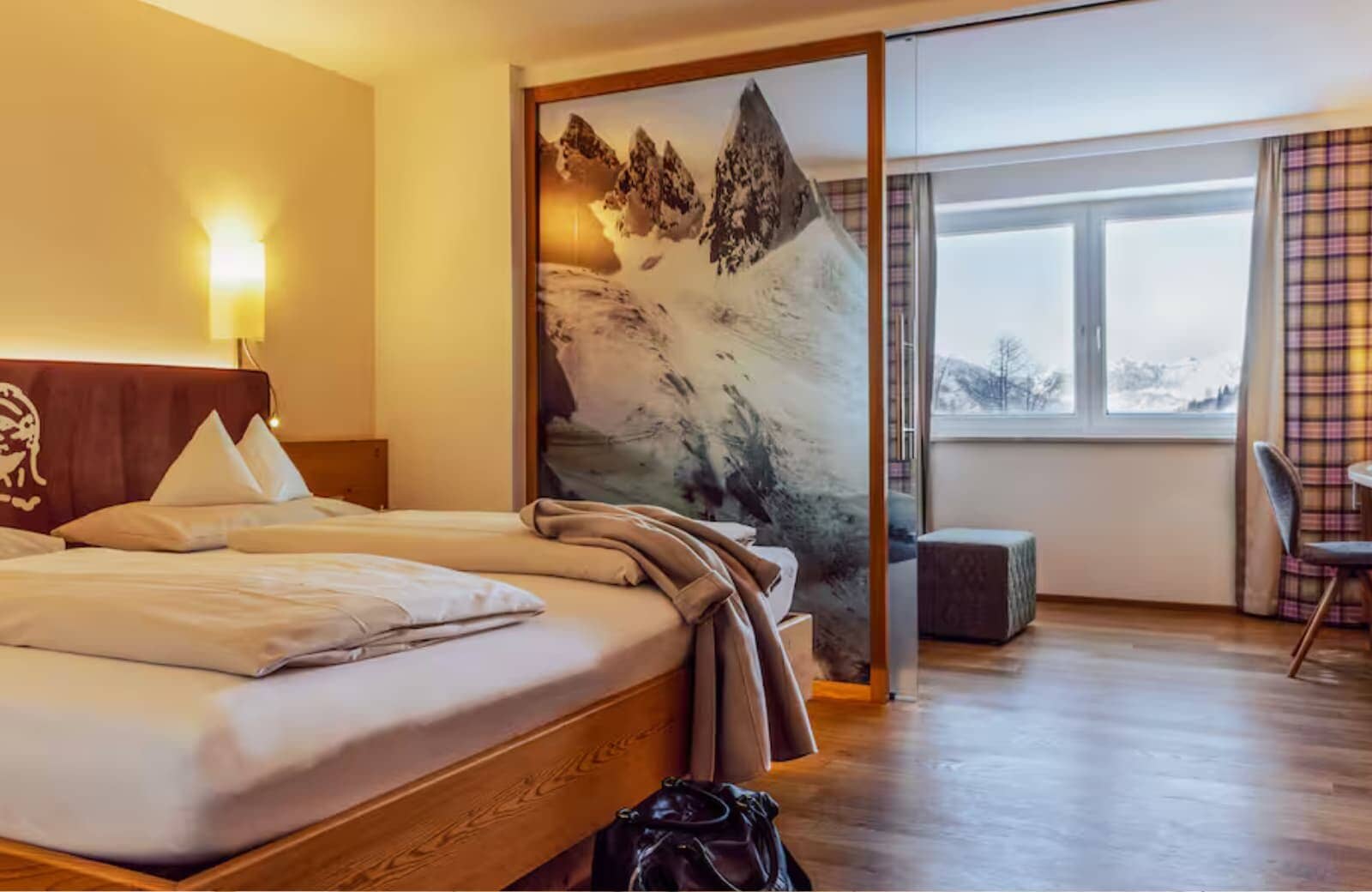 Guest bedroom with king bed and frosted glass mountain divider