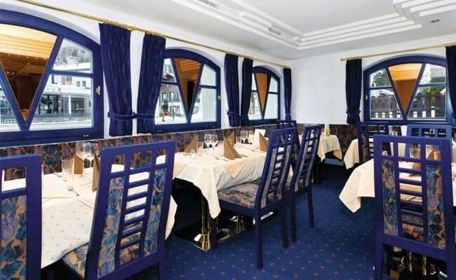 Dining room with white tablecloth service and street-level village views