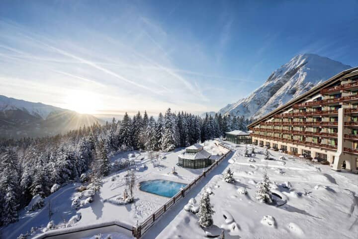 Ski-in/ski-out hotel exterior with heated outdoor pool and glass pavilions