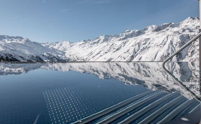 Infinity pool with panoramic Alpine views and walk-in stairs