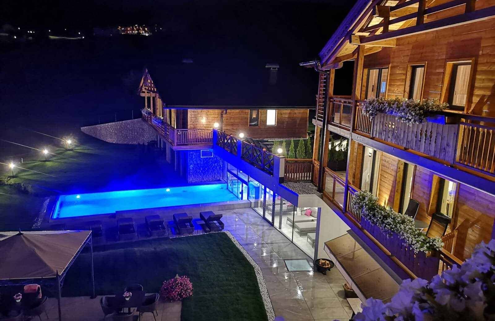 Multi-level wooden chalets with illuminated outdoor pool and multiple private balconies