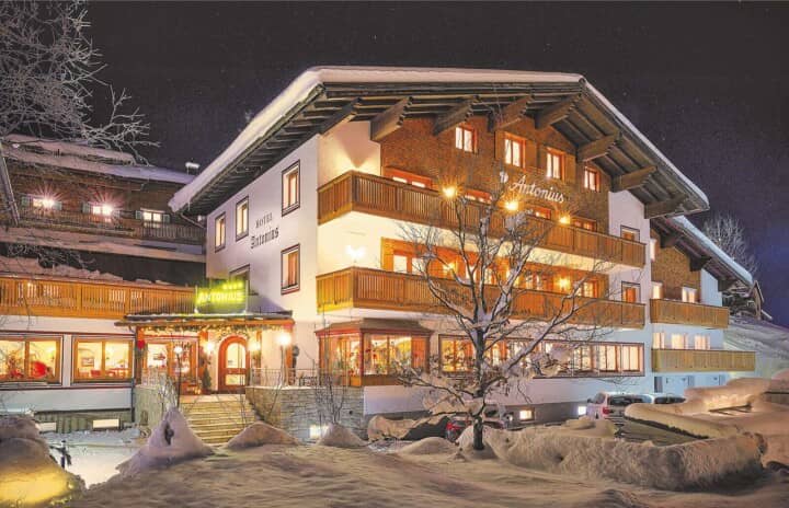 Alpine chalet exterior with multiple private balconies and snowy grounds