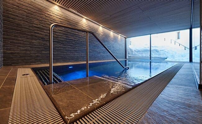 Indoor pool with floor-to-ceiling windows and snowy views