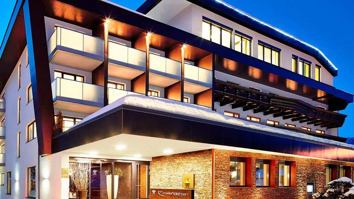 Hotel exterior featuring private glass-fronted balconies and covered entrance