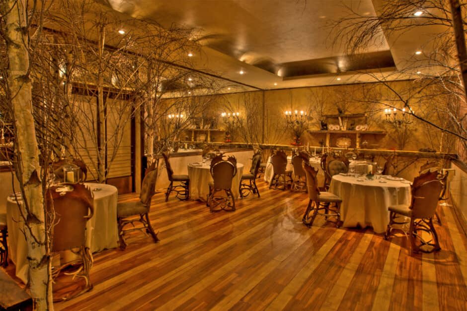 Dining area featuring birch tree trunks and antler chairs; seats 20