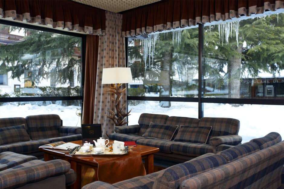 Lounge with plaid sofas and large windows showing snowy landscape