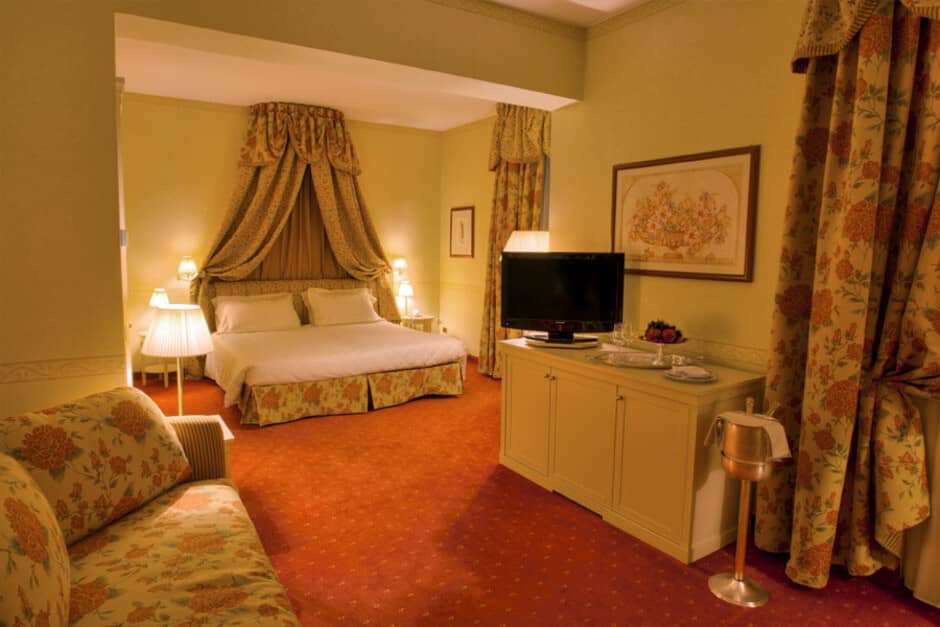 King bedroom with canopy bed and floral seating area