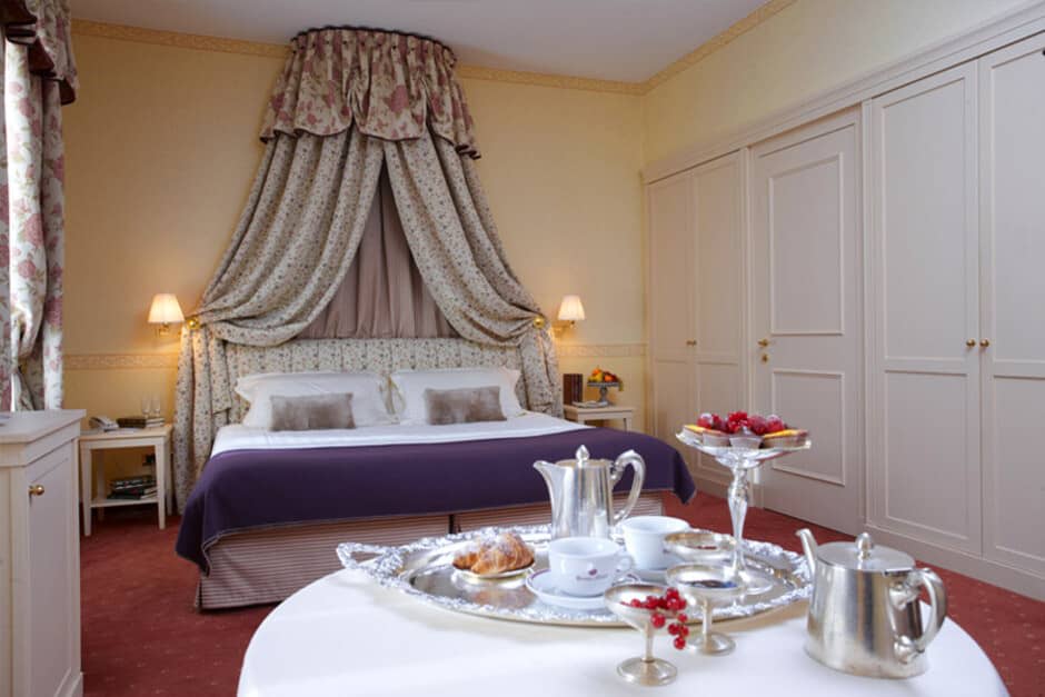King bedroom with floral canopy and wall of built-in wardrobes