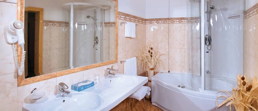 Bathroom with dual sinks and jetted soaking tub with shower