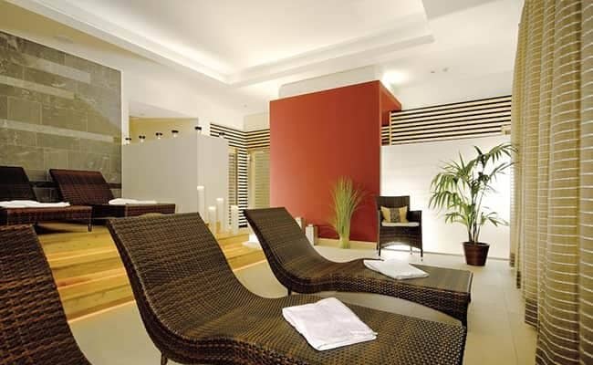 Spa relaxation room with wicker lounge chairs and indirect recessed lighting