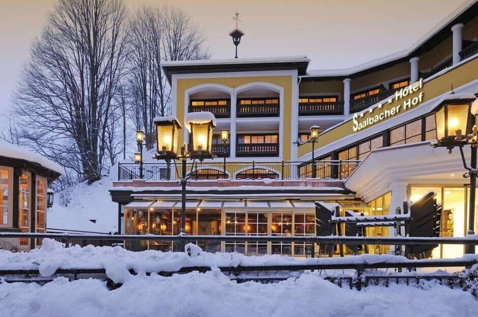Hotel exterior featuring snow-covered terrace and heated glass-enclosed dining area