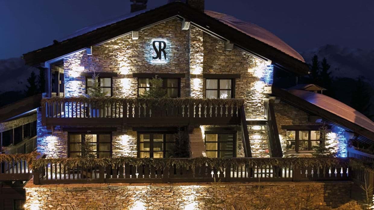 Stone-clad chalet exterior with multi-level wrap-around balconies