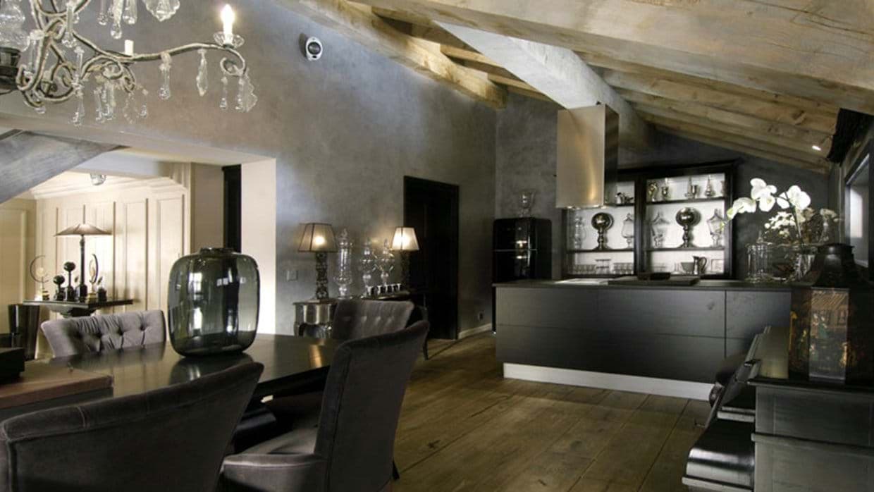 Open-plan dining and kitchen area with vaulted timber beams and induction cooktop