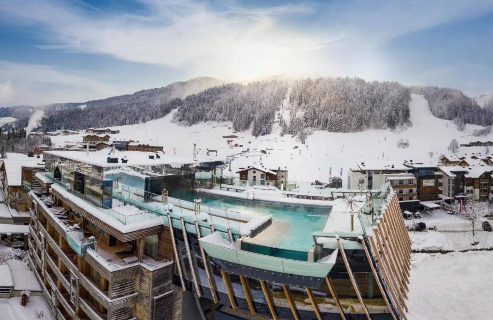 Rooftop infinity pool with glass walls and ski-in/ski-out mountain access