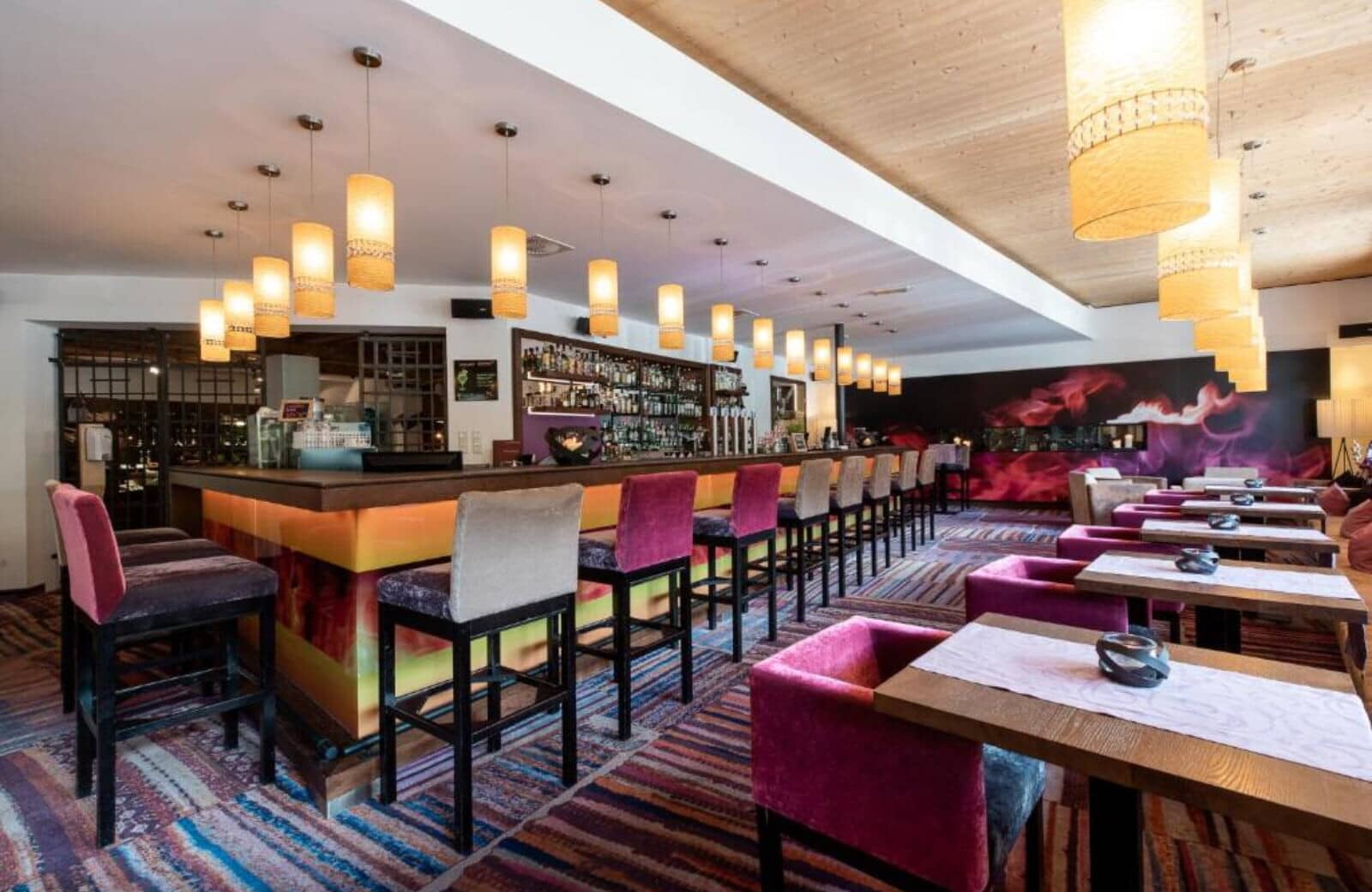 Lounge bar area with stool seating and adjacent cocktail tables