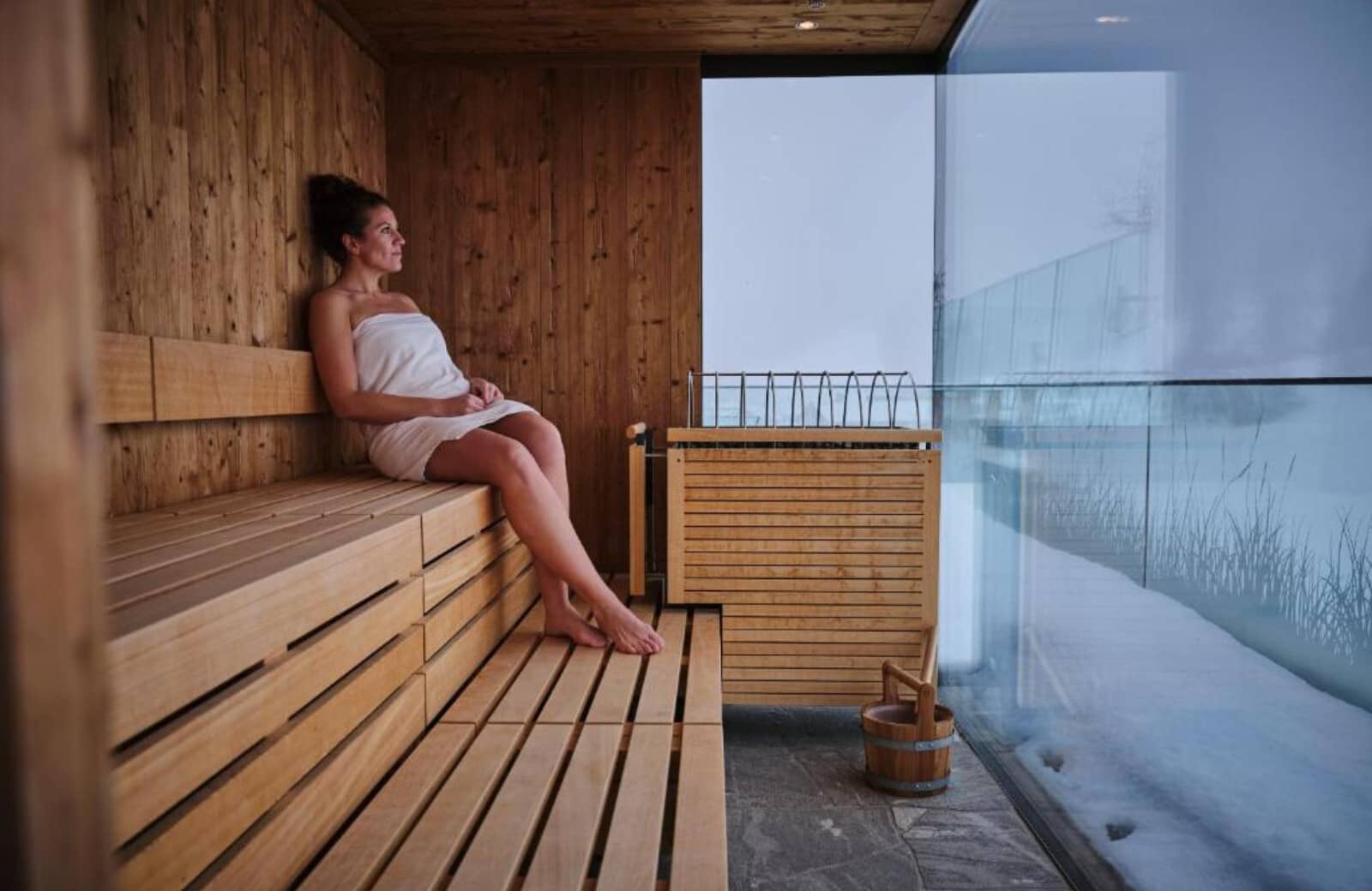 Private cedar sauna with floor-to-ceiling windows and snow views