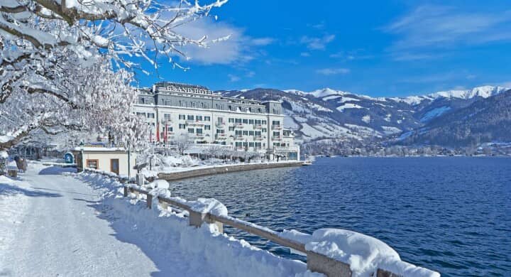 Lakeside hotel exterior with snow-covered mountain views