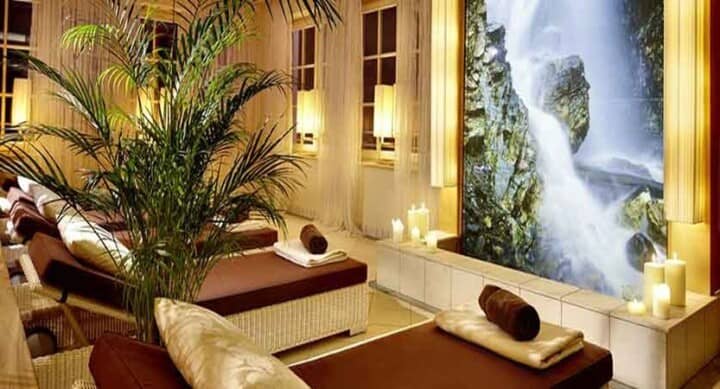 Spa relaxation room with daybeds and illuminated waterfall mural