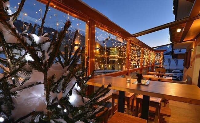 Covered outdoor terrace with heated dining area and mountain views