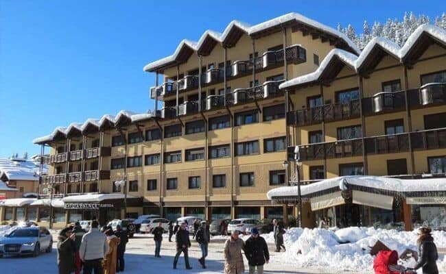 Ski-in/ski-out hotel exterior with private balconies and ground-floor parking