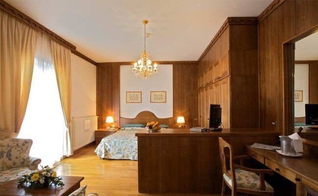 Bedroom with wood paneling, built-in wardrobes, and dedicated desk workspace