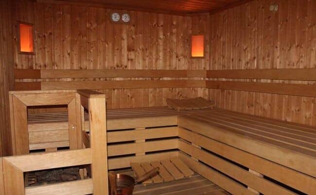 Cedar sauna with multi-level bench seating and electric heater