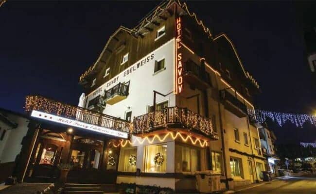 Hotel exterior at night with festive lighting and private balconies